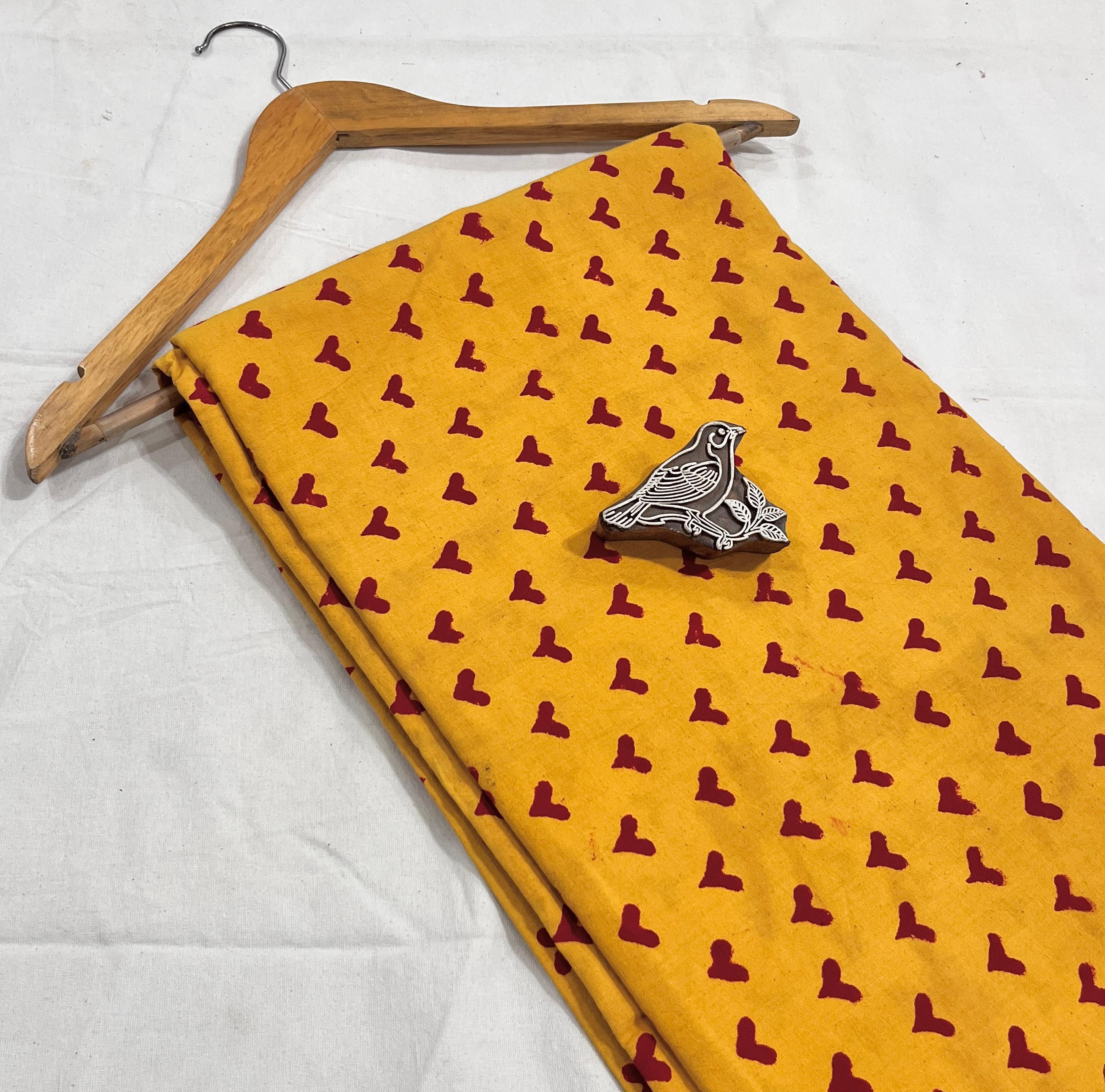 Yellow-red heart motif pure cotton Dabu handblock printed fabric, artisan textile for bulk orders.